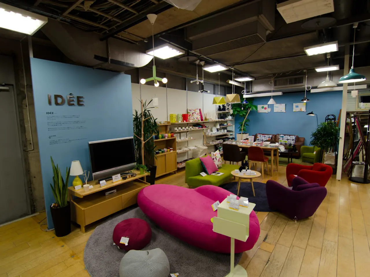 Home appliances and furniture are placed representing a home environment in a store. There is a TV...